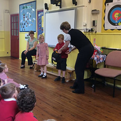 Kay Reeve [right] presenting the defibrillator to pupils and staff of Terrington St John's Junior School