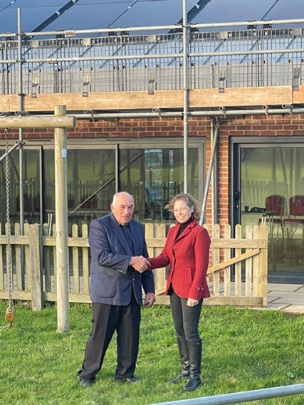 George Brett-Reynolds welcomes Susan Falch-Lovesey to Wighton Village Hall.